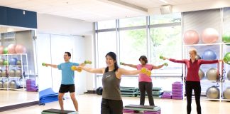Dumbbells in both their outstretched hands building upper body s