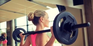 Exercițiu cu bara cu haltere din poziția în picioare pentru masa musculară a umerilor