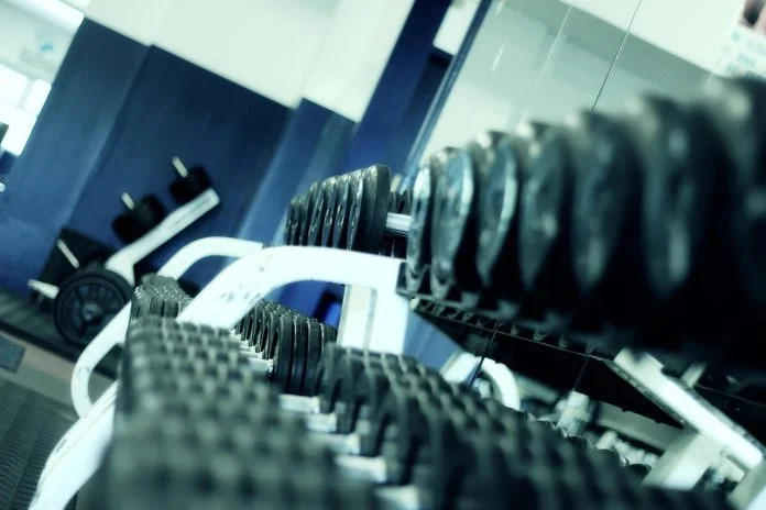 Exercițiu de ridicarea greutăților în lateral, din picioare, pentru consolidarea umerilor