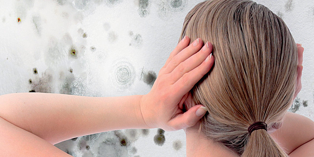 Femeie speriată de igrasia de pe pereți